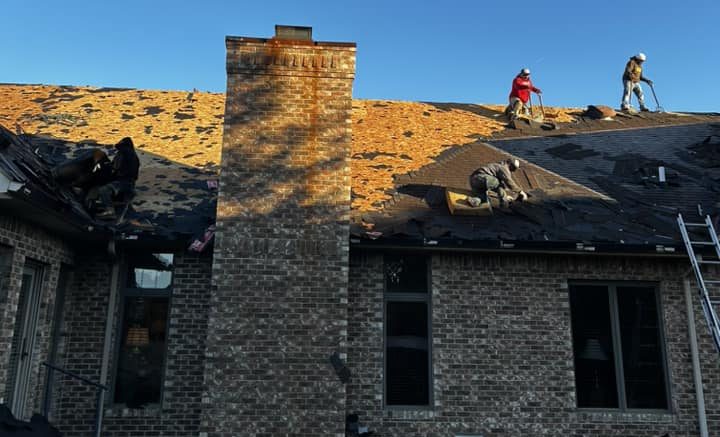 In Progress roof replacement in Terre Haute Indiana by Guarantee Roofing. The Roofers are spaced out across the roof.