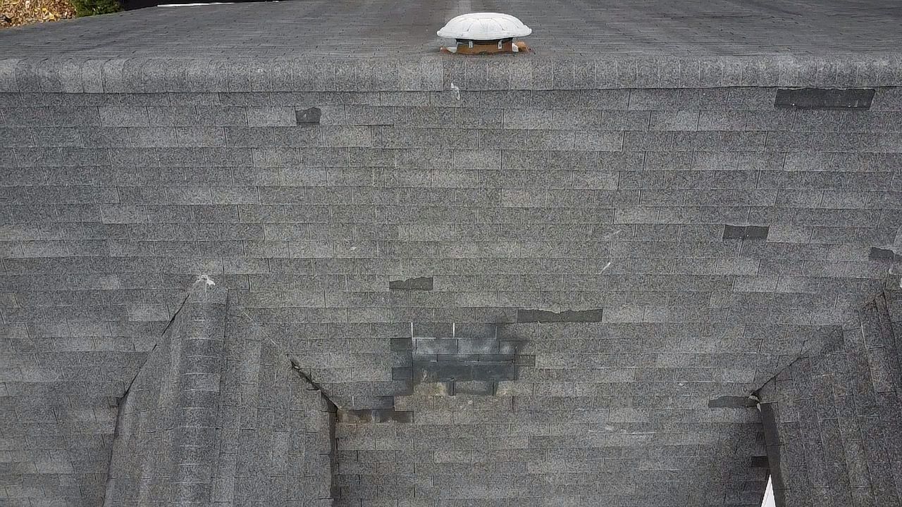 Aerial view of shingle damage on a home in Terre Haute. Some shingles were replaced at one point but not done right and don't match. Guarantee Roofing and Fence was called to come out and repair the roof to save it from damage.